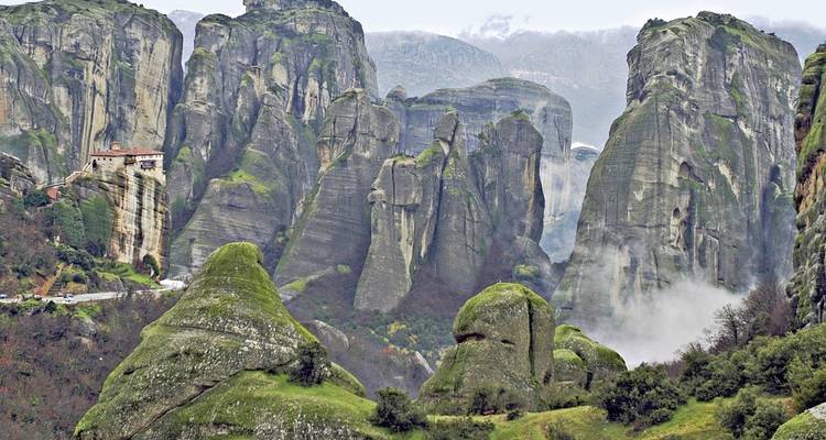 Paysage dramatique de pics rocheux avec un monastère.