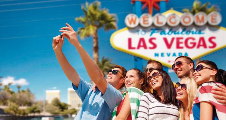 Groupe de personnes prenant un selfie devant le panneau Welcome to Las Vegas.
