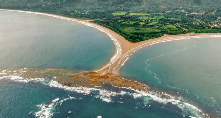 Luchtfoto van een zandformatie die zich uitstrekt in de oceaan.
