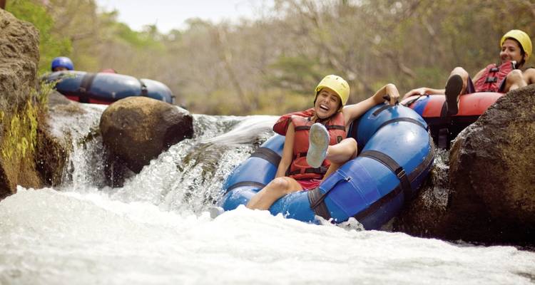Des personnes profitant d'une descente en bouée sur un toboggan aquatique avec des rires et de l'excitation.