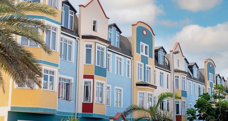 Colorful colonial buildings with a palm tree in front.