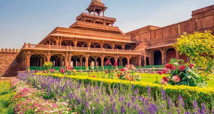 Historic building surrounded by a vibrant garden