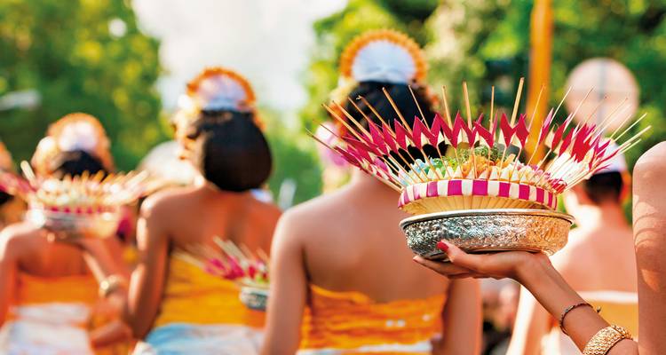Menschen, die an einer traditionellen balinesischen Prozession mit Opfergaben teilnehmen.