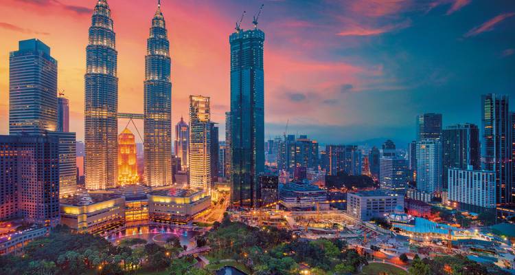 Kuala Lumpur cityscape at night featuring Petronas Towers.