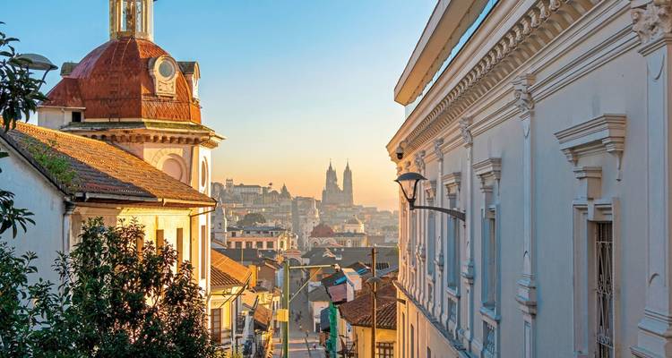 Stadsstraat met historische gebouwen tijdens zonsondergang.