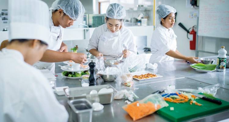 Un groupe de chefs préparant des plats dans une cuisine.