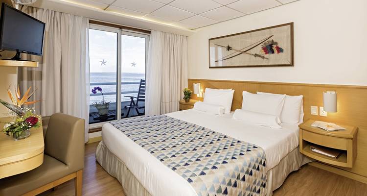 Chambre d'hôtel moderne avec vue sur l'océan par la fenêtre et décoration minimaliste.