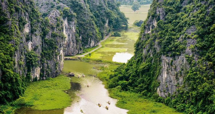 Luchtfoto van een schilderachtige rivier met weelderig groen en torenhoge kalkstenen kliffen.
