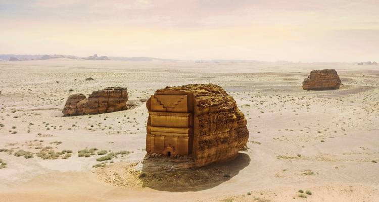 An isolated tomb structure in a desert landscape.