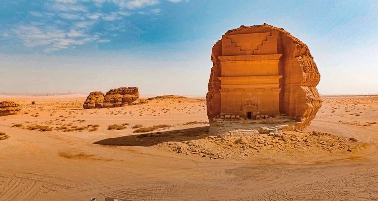 An ancient tomb structure in a vast desert.