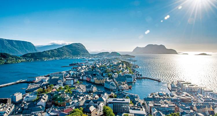 Luftaufnahme einer Küstenstadt mit Bergen und Meer.