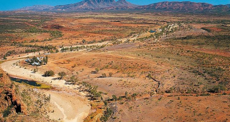 Amplio paisaje aéreo del centro de Australia con tierra roja y vegetación escasa.