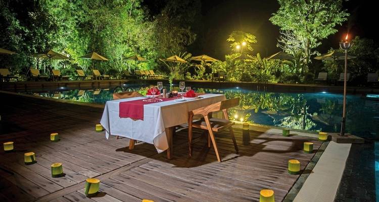 Romantic dinner setup by a pool at night