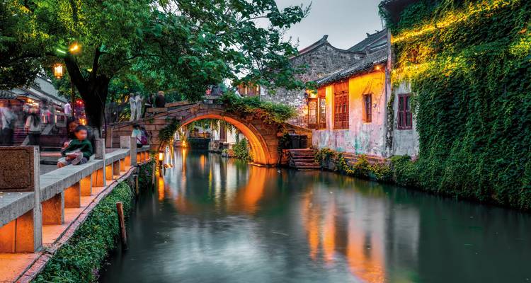 Canal illuminé avec architecture traditionnelle sous la lumière du soir.