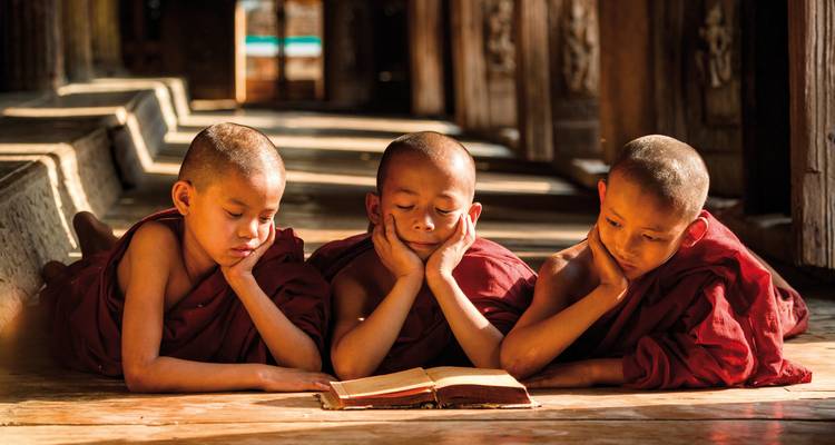 Trois jeunes moines lisant ensemble dans un temple.