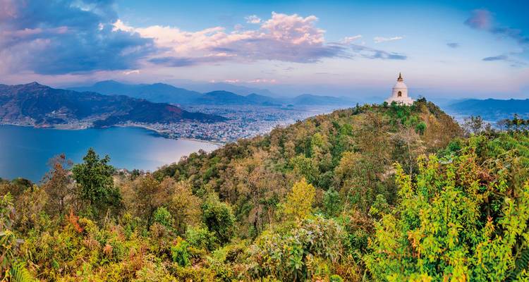 Pagode surplombant un lac et une ville dans un cadre pittoresque.