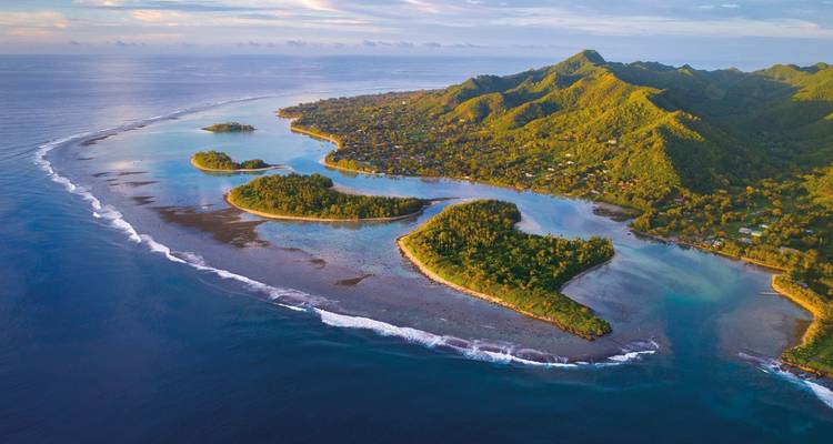 Vue aérienne d'une île luxuriante des îles Cook au coucher du soleil.