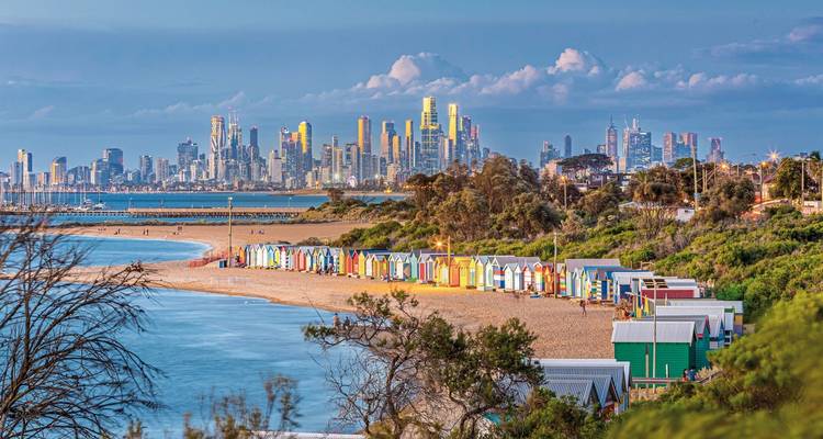 Cabanes de plage colorées avec horizon urbain en arrière-plan