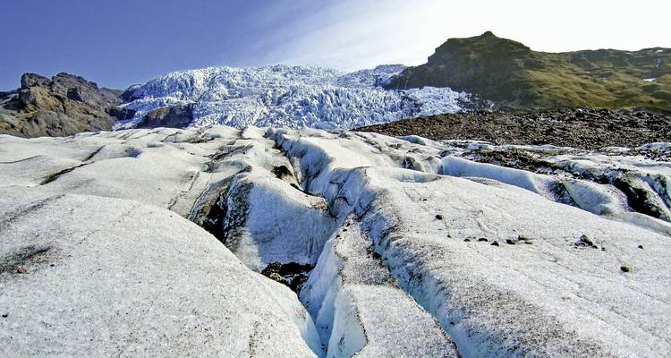 Glacier recouvert de neige sous un ciel bleu dégagé.