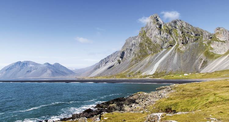 Vue côtière de montagnes rocheuses rencontrant l'océan.