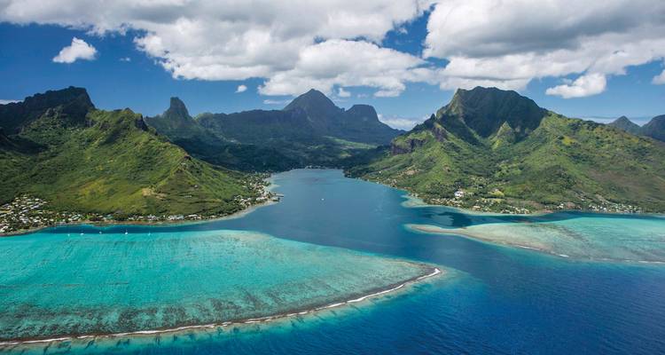 Prachtige baai omgeven door weelderige bergen en turquoise water.