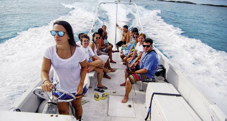 Un grupo de personas sonriendo en un barco en el océano.