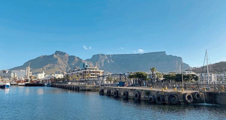 Der Table Mountain, der sich über Kapstadts V&A Waterfront erhebt, gesehen über ruhigem Hafenwasser
