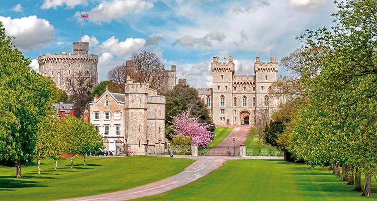 Windsor Castle with lush green gardens and a clear sky.