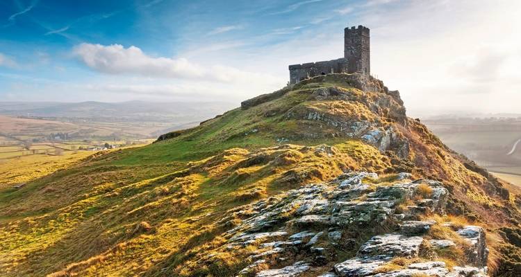 Hilltop with a stone tower and expansive landscape view.