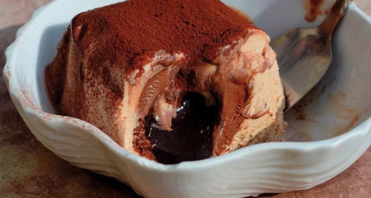 Primer plano de un postre con chocolate y espolvoreado de cacao en polvo.