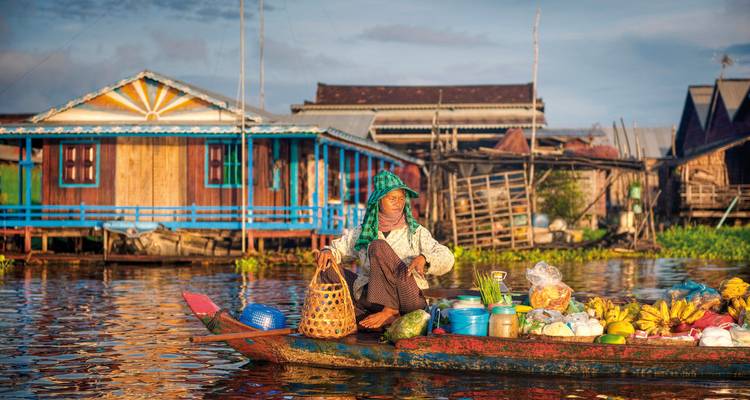 Persoon die fruit verkoopt op een boot in een drijvend dorp.
