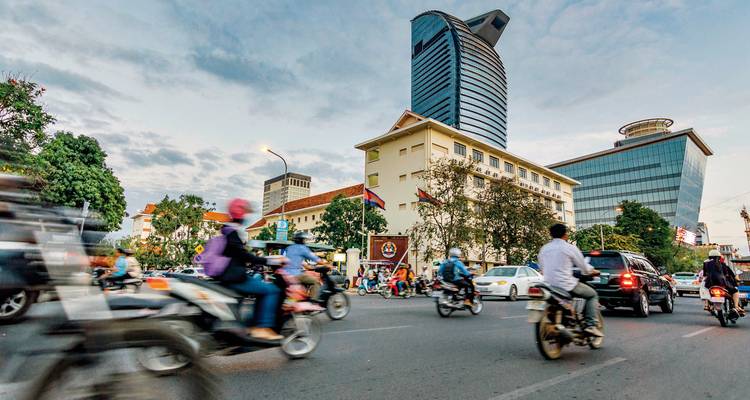 Drukke straatscène met motorfietsen en moderne gebouwen.