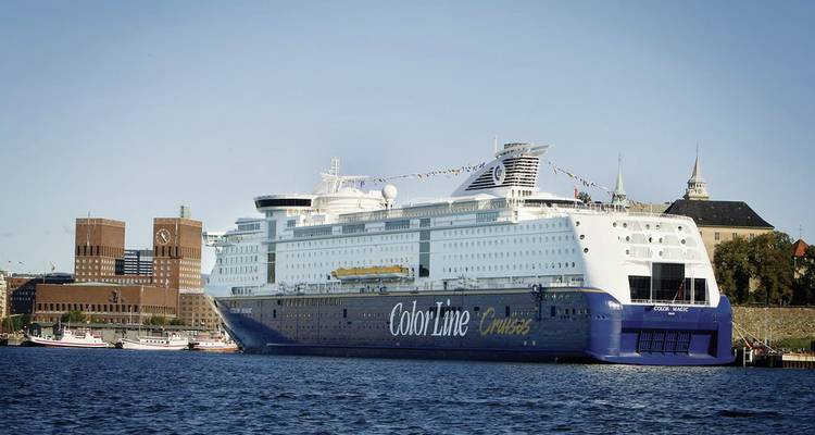 Een cruiseschip aangemeerd bij een haven met historische gebouwen.