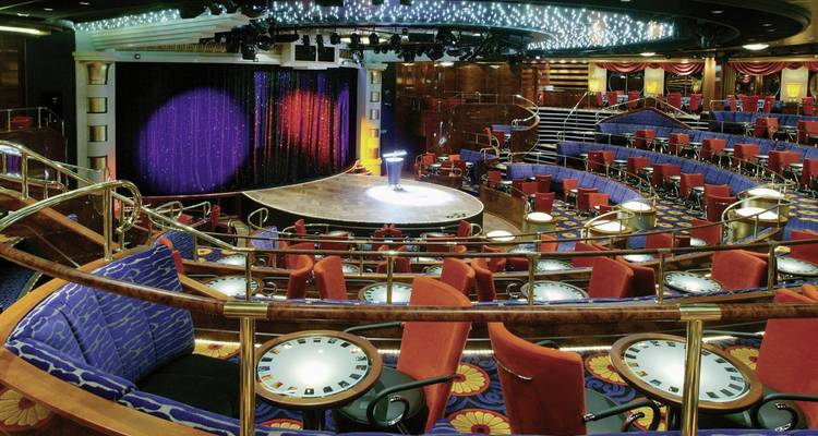 Interieur van een kleurrijke entertainmentlocatie met podium en zitplaatsen.