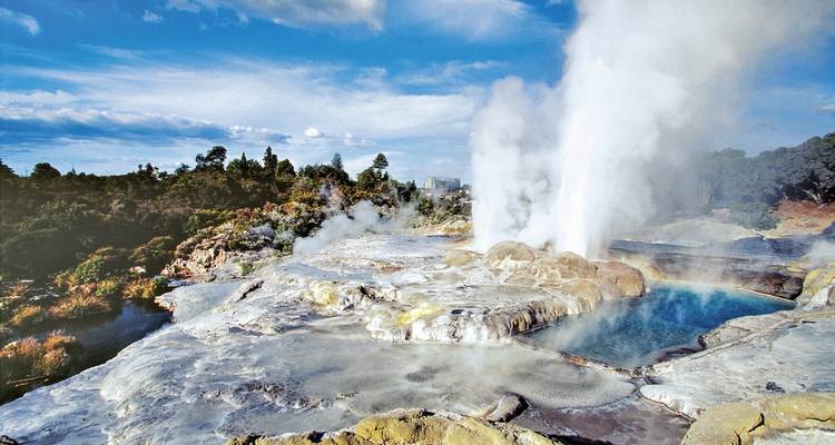 Une zone géothermique avec des sources chaudes et de la vapeur dans un paysage rocheux.