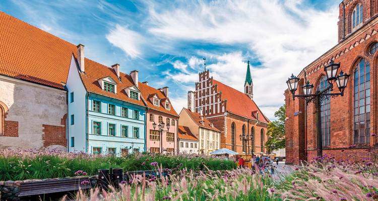 Historische straat met kleurrijke gebouwen en sierlijke kerk.