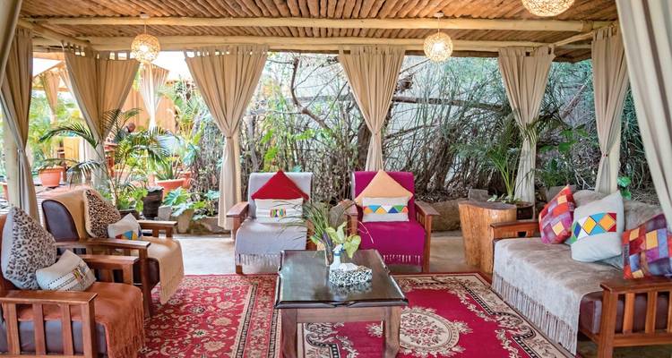 Lounge-Bereich mit bunten Kissen und Gartenblick