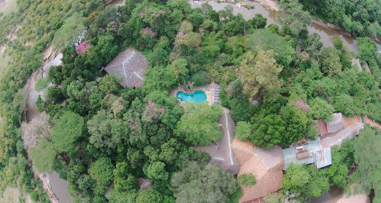 Luftaufnahme eines Resorts mit Pool in einer tropischen Landschaft