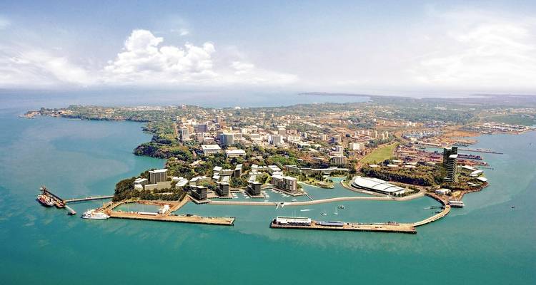 Aerial view of a coastal city with a lush skyline and harbor.