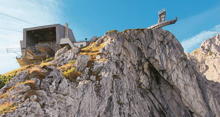 Felsiger Berg mit Aussichtsplattform und Seilbahnstation.