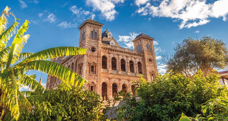 Bâtiment historique avec une végétation luxuriante sous un ciel dégagé.