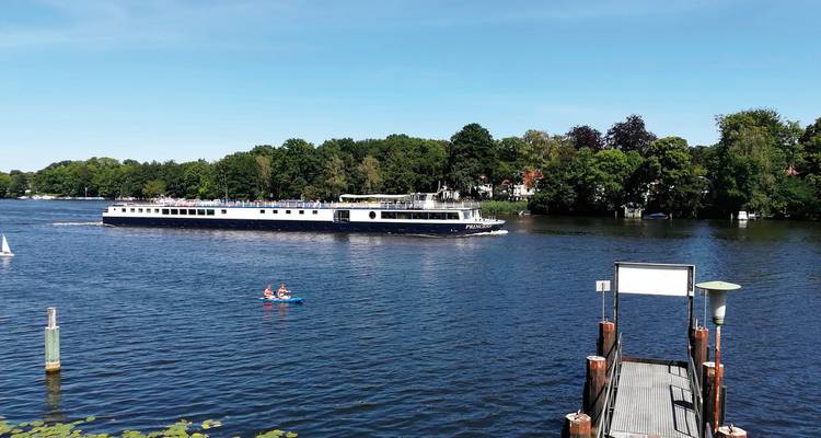 Navire de croisière 'Princess' naviguant sur une rivière calme.