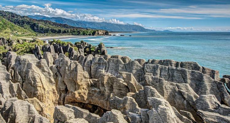 Rochers Pancake et paysage côtier sous un ciel lumineux.