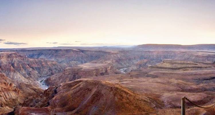 Weiter Panoramablick in die rauen, mehrfarbigen Tiefen des Fish River Canyon bei Sonnenaufgang.