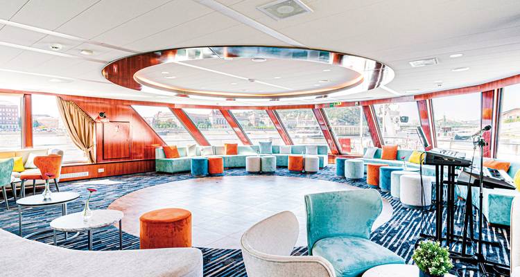 Espace salon chic à l'intérieur d'un navire de croisière avec des sièges colorés.