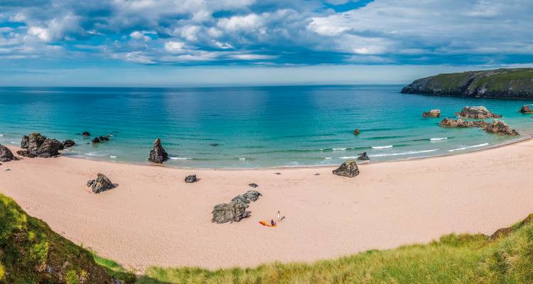 Une plage pittoresque avec une eau turquoise et des rochers.