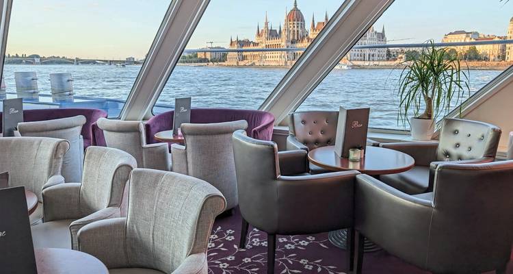 Vue depuis la salle à manger d'un bateau de croisière avec le Parlement de Budapest en arrière-plan.
