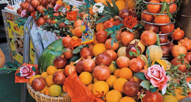 Uitstalling van verse seizoensfruit en groenten op een markt.