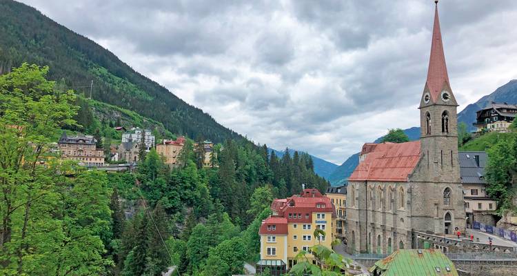 A scenic view of a town with a church steeple in a valley.