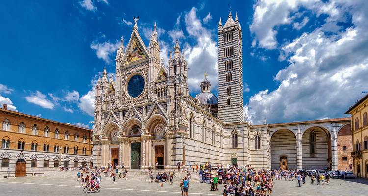 Der Dom von Siena mit Menschen auf dem Platz davor.
